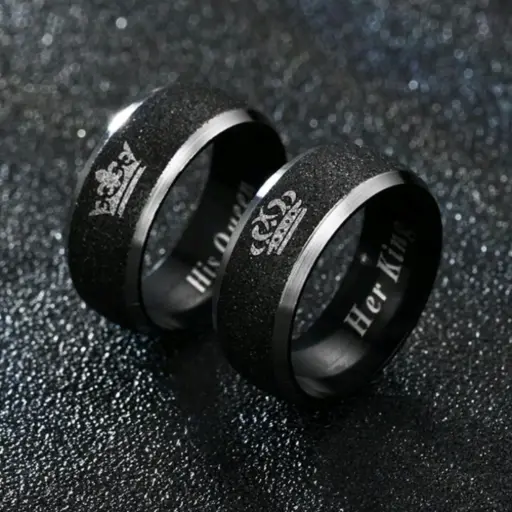 [AD0028] Set de dos anillos plateados con linea negra texturizada en el centro, con el grabado de "His Queen" y "Her King" dentro del anillo.
